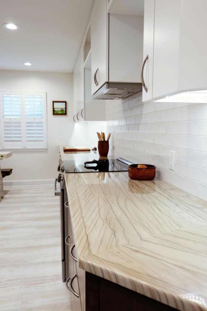 Residential kitchen with white tile and wood cabinets