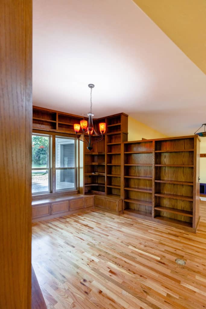 Interior home renovation - Remodeling. Bookshelves with wood flooring and windows.