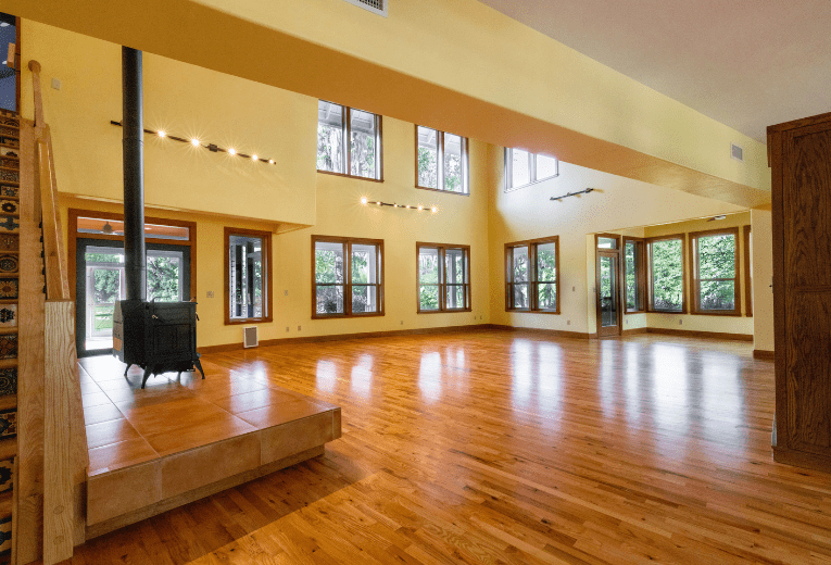 Micanopy Home Interior Renovation - Front room areas with wood floors, windows, and a fireplace.