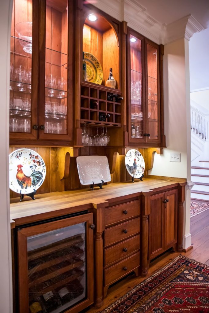 Picture of a butler's pantry equipped with wood cabinets and stocked with china.